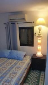 a bedroom with a bed with a lamp and a window at Studio Hadera in H̱adera