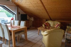 ein Wohnzimmer mit einem Tisch und Stühlen sowie ein Esszimmer in der Unterkunft Ferienwohnungen Weitmann in Ockfen