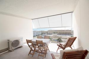 ein Wohnzimmer mit einem Tisch und Stühlen sowie einem großen Fenster in der Unterkunft Global Properties, Moderno apartamento con terraza y vistas al mar in Canet d'en Berenguer