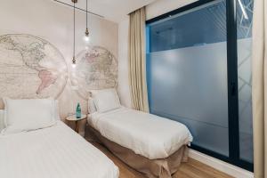 a room with two beds and a large window at Galmen Suites in Seville