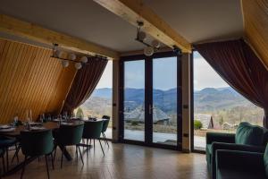 a dining room with tables and chairs and large windows at CABANA 7 CRESTE in Borşa