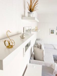 a white living room with a couch and shelves at Ilona Apartments -"Home Away From Home" in Kotka