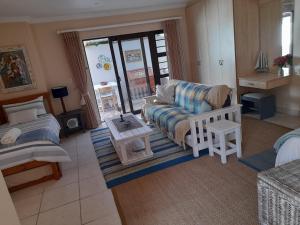 a living room with a couch and a table at Barnard Self-Catering Apartments in St Francis Bay
