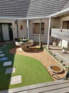 a backyard with a fire pit and grass at Barnard Self Catering Apartments in St Francis Bay