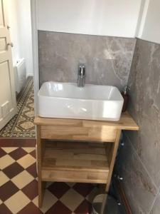 a bathroom with a white sink on a wooden table at LE LORITZ in Nancy