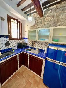 een keuken met blauwe werkbladen en een blauwe koelkast bij CasaCamilla in Piombino