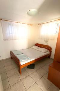 a bedroom with a bed in a room with windows at Apartmani Devic in Tivat