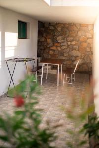 a table and chairs in a room with a stone wall at Apartmani Devic in Tivat