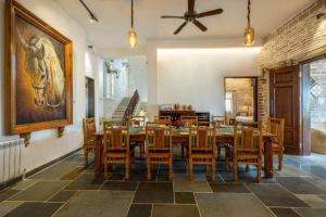 a dining room with a table and wooden chairs at Moonstone, Bhopal, amã Stays & Trails in Shamsgarh