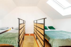 two beds in a bedroom with a skylight at Loft House Rozewie in Jastrzębia Góra