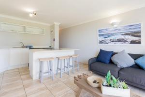 a living room with a couch and a kitchen at Chaka's Cove 66 in Ballito