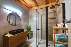ein Bad mit einem Waschbecken und einem Spiegel in der Unterkunft Biktot Nofim in Manot