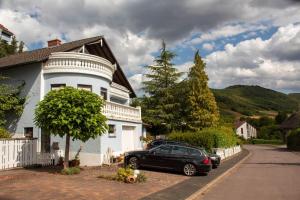 a black car parked in front of a white house at Ferienwohnungen Weitmann in Ockfen