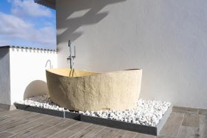 una vasca da bagno poggiata su un cumulo di rocce di LACASA Apartments Cotillo a Cotillo