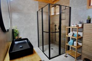 a shower with a black seat in a bathroom at Biktot Nofim in Manot
