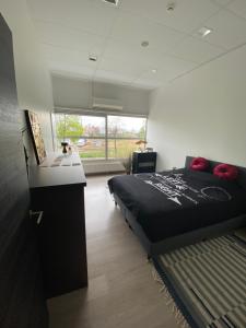 a bedroom with a bed and a large window at De Wellnessloft Bocholt in Bocholt