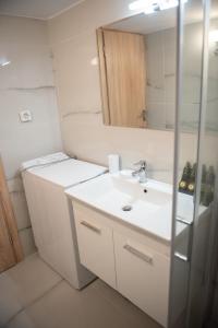 W łazience znajduje się biała umywalka i lustro. w obiekcie Cozy flat 5min to subway station (EPIDAMN) w Atenach