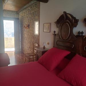 1 dormitorio con cama roja y cabecero de madera en Locanda La Posta, en Castel dʼAiano