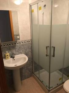 a bathroom with a sink and a glass shower at adosado con piscina a 10 minutos de Alicante in Alicante