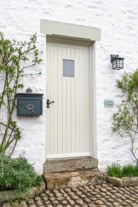 une porte blanche sur le côté d'un bâtiment blanc dans l'établissement Entire cottage & private garden in Scorton, à Scorton