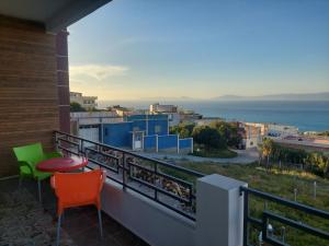 einen Balkon mit einem Tisch, Stühlen und Meerblick in der Unterkunft Ghougine Serenity Residence in Tangier