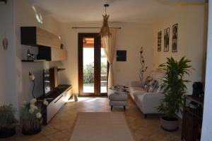 a living room with a couch and a tv at Sweet House in Villasimius