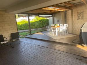 a porch with a table and chairs on a patio at The Handbreak in Dunsborough