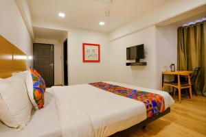 pokój hotelowy z łóżkiem i telewizorem w obiekcie Hotel Highway Residency - Andheri Chakala w Bombaju