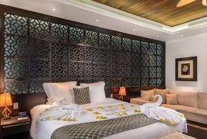 a bedroom with a large bed and a couch at Banana Island Resort Doha by Anantara in Doha