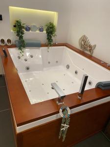 a large bath tub with a chain in a bathroom at De Wellnessloft Bocholt in Bocholt