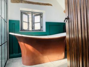 a bath tub in a bathroom with a window at THE APPLE LOFT - Rustic luxury one bed cottage in Strete