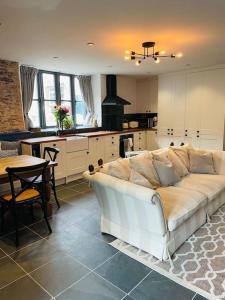 a living room with a white couch in a kitchen at THE APPLE LOFT - Rustic luxury one bed cottage in Strete
