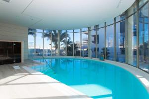 een groot zwembad in een gebouw met ramen bij Green Hills 1-2 in Orihuela