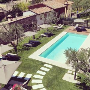 une image d'une piscine dans une cour avec parasols dans l'établissement Il cantuccio sul Garda - Relais di charme, à Cavaion Veronese