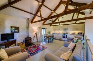 a large living room with a couch and a kitchen at Trevadlock Manor Self Catering Cottages in Launceston