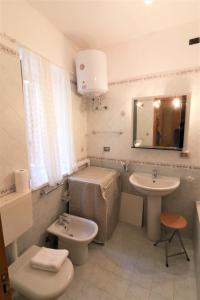un bagno con lavandino, water e specchio di Cefalù in Summer a Cefalù