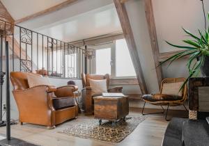 - un salon avec des fauteuils en cuir et un escalier dans l'établissement La Chatelaine, à Egmond aan Zee