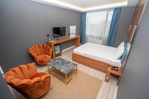 a bedroom with a bed and two chairs and a television at 216 Center Suite in Istanbul