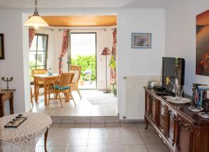 a living room with a television and a table and chairs at Ferienwohnungen Weitmann in Ockfen