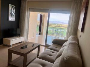 ein Wohnzimmer mit einem Sofa, einem TV und einem Tisch in der Unterkunft Schöne Wohnung mit Top Aussicht in Guardamar del Segura