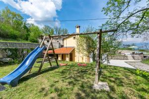 Un parque infantil con dos toboganes en un patio. en House Rada i Stanisav, en Mošćenička Draga