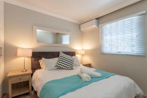 a bedroom with a bed and a window at Chaka's Cove 66 in Ballito +13 photos