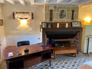 ein Wohnzimmer mit einem Schreibtisch und einem Kamin in der Unterkunft Très belle propriété avec tennis à 1h de Paris 