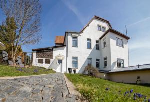 a white house with a cobblestone driveway at Mountain Lake View in Güntersberge