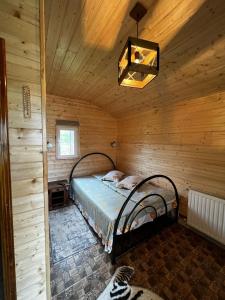 a bedroom with a bed in a wooden cabin at Pensiunea Colt de Rai, Vistisoara in Stațiunea Climaterică Sâmbăta