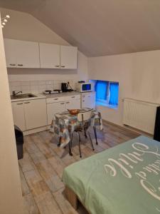a kitchen with white cabinets and a table and chairs at Résidence Mantekila in Marcinelle