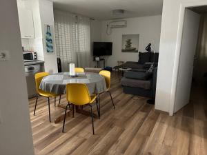 una sala da pranzo e un soggiorno con tavolo e sedie. di Šibenik apartment a Šibenik