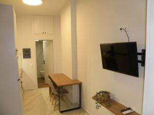 a room with a television on a wall with a table at Modern lifestyle flat close to the sea. in Gázion