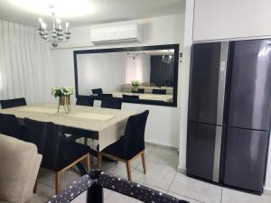 a dining room with a table and a refrigerator at בית הנשיא in Safed