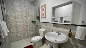 a bathroom with a sink and a toilet and a mirror at Cozy 4 bedroom villa in Dubai